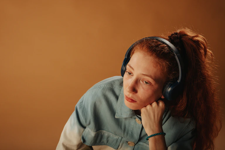 sad redheaded girl with headphones on
