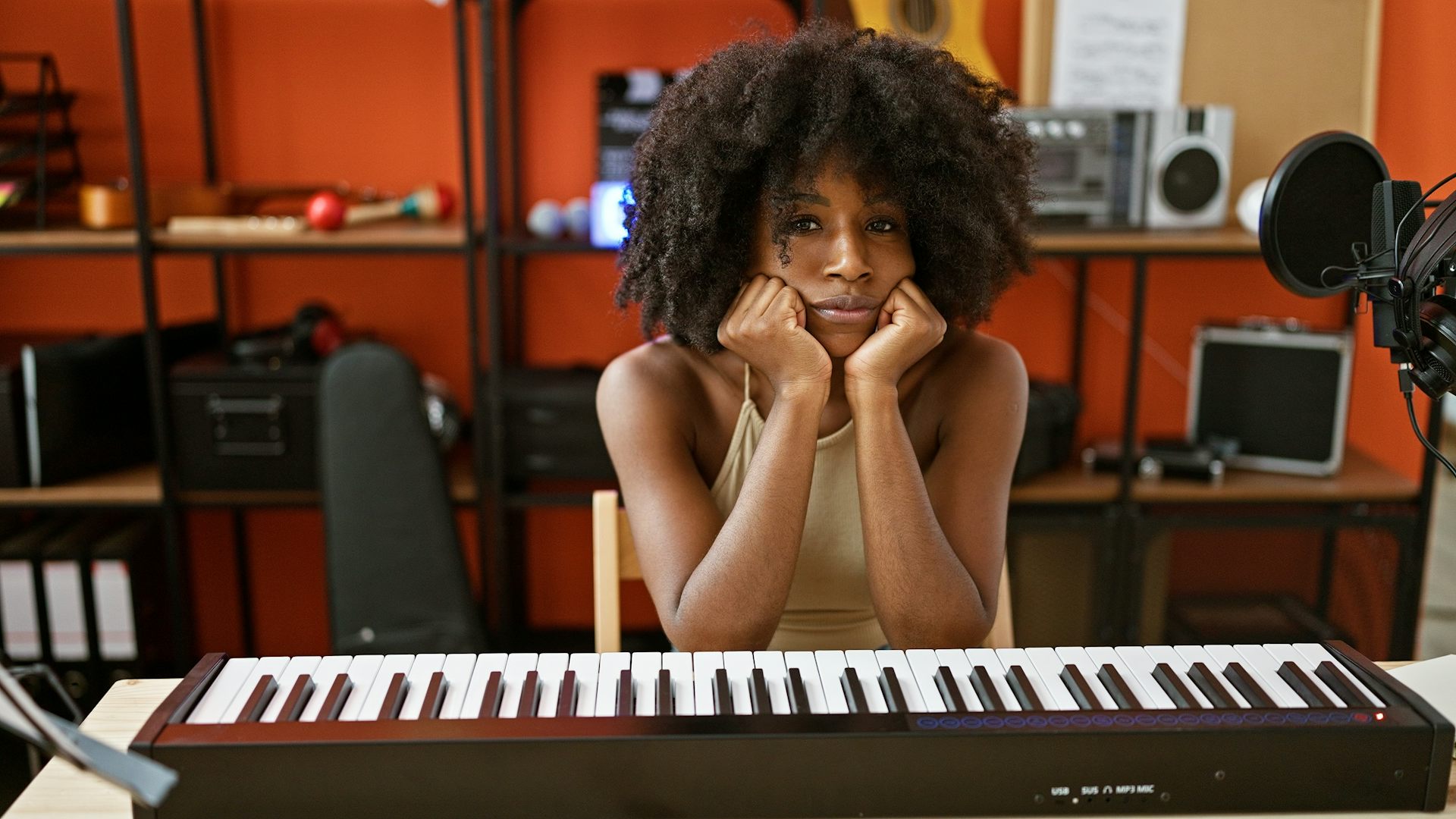 black woman sat at a keyboard, looking fed up.