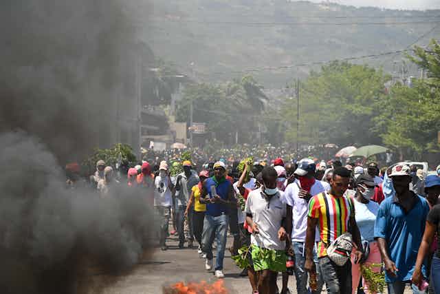 La fumée noire de pneus en feu est visible lors d'une manifestation contre l'insécurité, le 7 août 2023, près de la maison officielle du Premier ministre à Port-au-Prince, Haïti. 