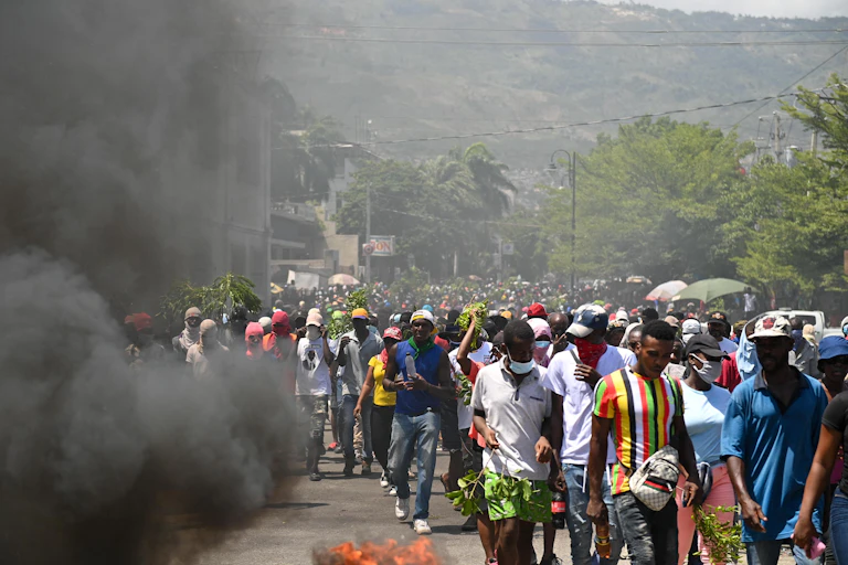 La fumée noire de pneus en feu est visible lors d'une manifestation contre l'insécurité, le 7 août 2023, près de la maison officielle du Premier ministre à Port-au-Prince, Haïti.