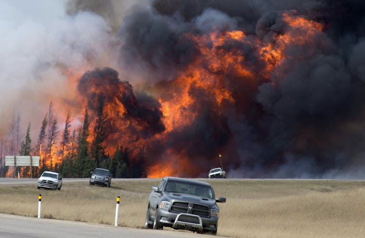 wildfire burns near abandoned cars