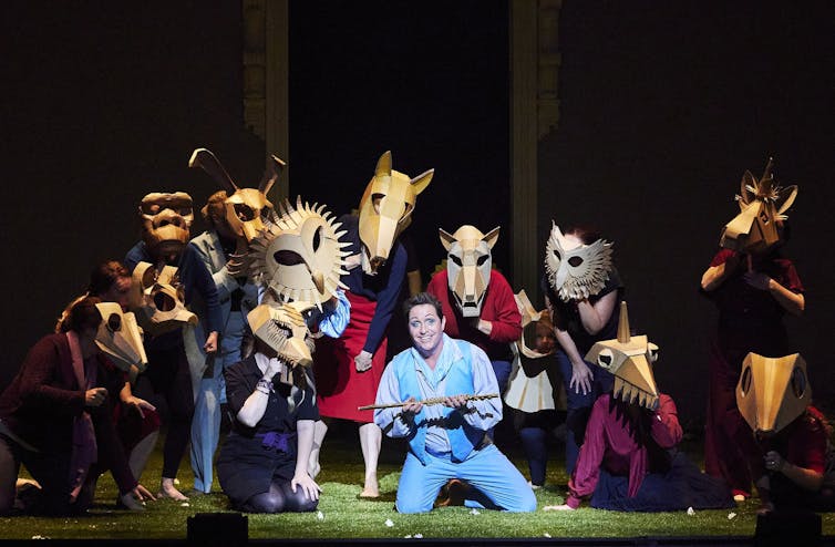 Michael Smallwood and the Opera Australia Chorus perform onstage.