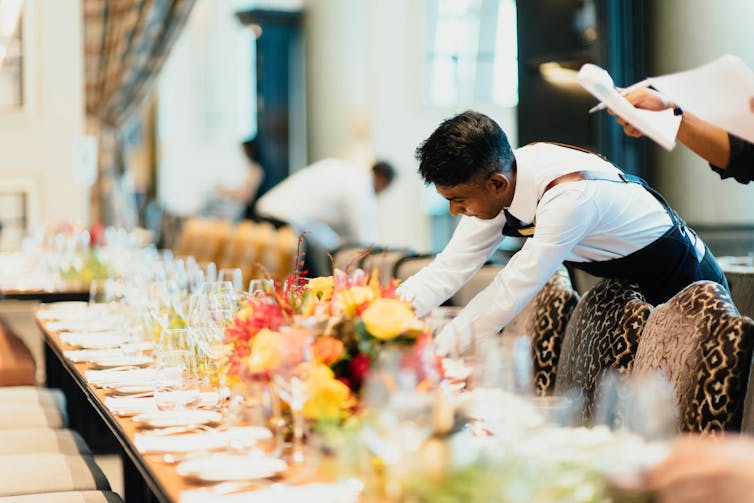 Waiter sets table