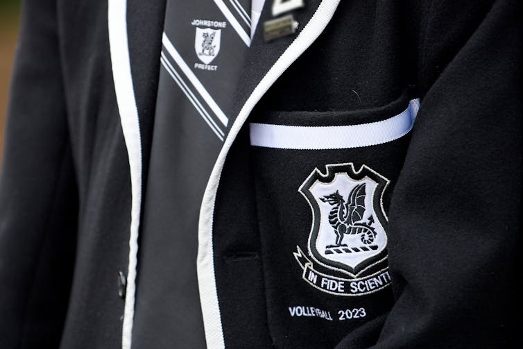 A close up of a student in a Newington blazer with the school crest and tie.