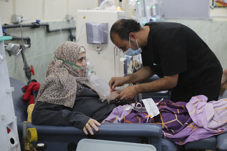 A man in a surgical mask tending to a woman wearing an oxygen mask