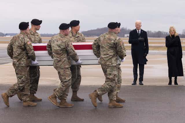 US soldiers carry a coffin past the PU president Joe Biden and the First Lady, Jill Biden