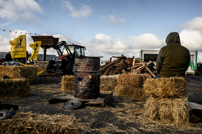 Un manifestant est assis à un barrage du péage de l'autoroute A43 lors d'une manifestation d'agriculteurs sur les salaires, les taxes et les réglementations, à Saint-Quentin Fallavier, près de Lyon, dans le centre-est de la France, le 2 février 2024.