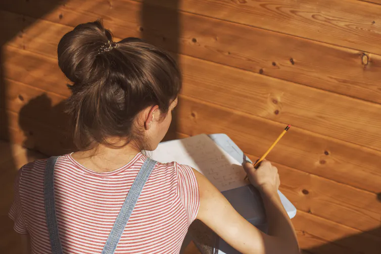 Jeune femme écrivant sur un cahier