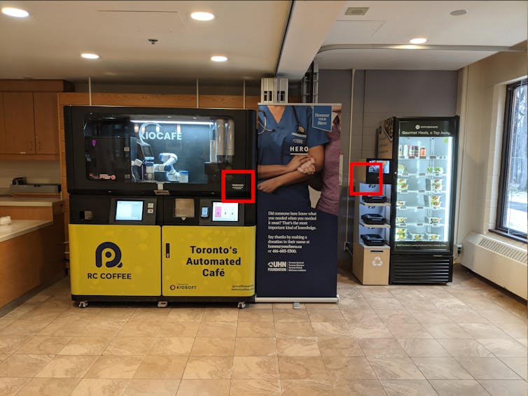 An RC Coffee and KitchenMate smart fridge sit next to each other in a lobby. Small stickers on the side of each machine that present contact information are outlined.