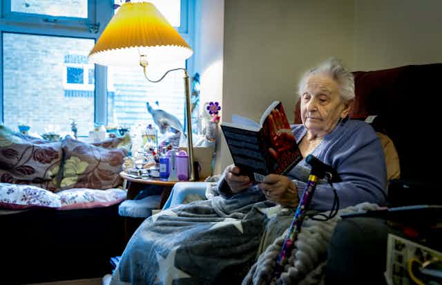Older woman reads on her lounge chair
