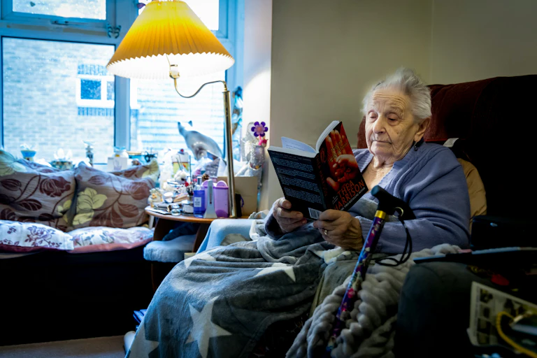 Older woman reads on her lounge chair