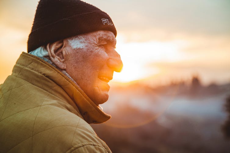 Older man watches sun rise