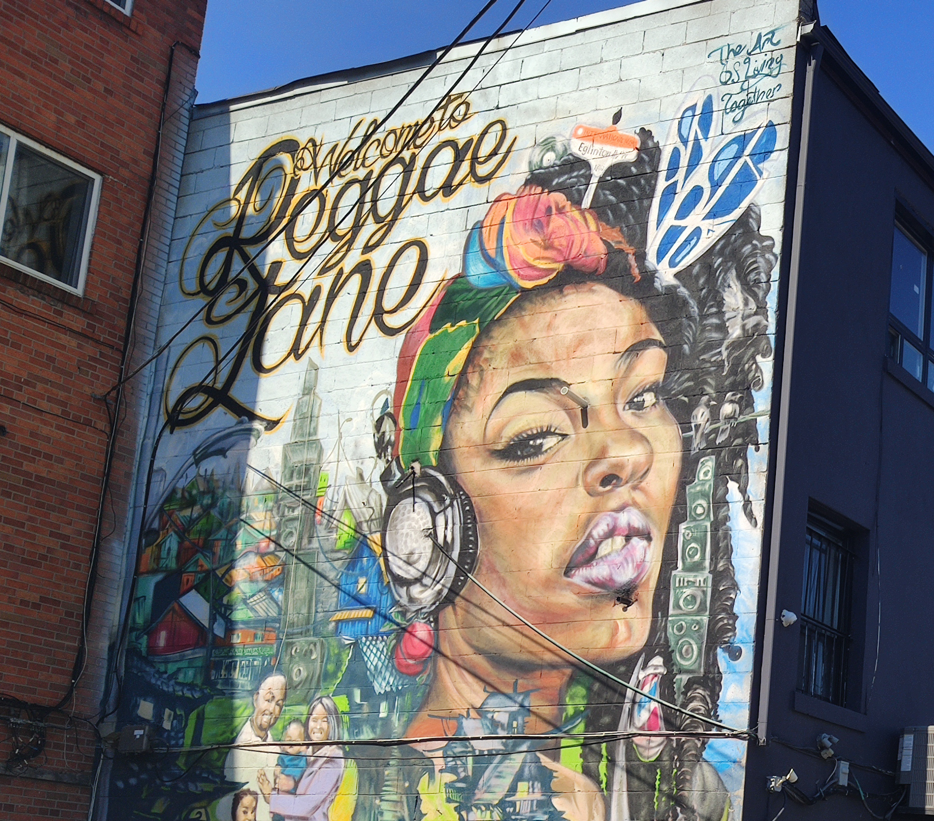 A  mural featuring a Black woman and the words: Welcome to Reggae Lane.