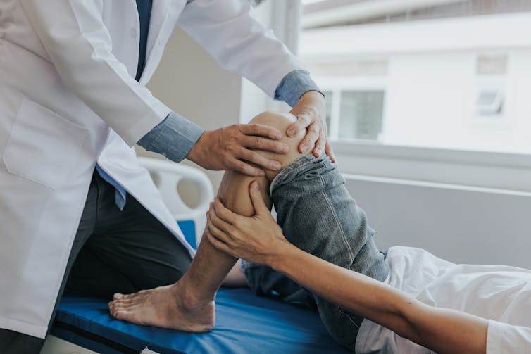 medical professional assesses child's knee