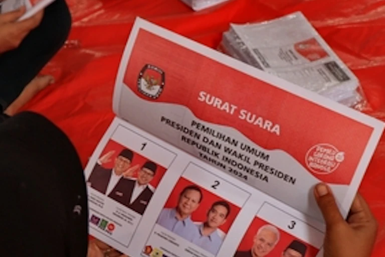 Seorang perempuan melipat surat suara untuk Pemilihan Presiden 2024.