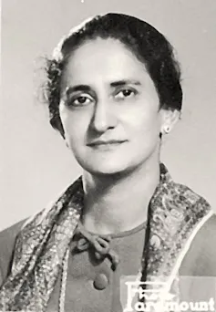 A black and white portrait of a young woman who is smiling slightly