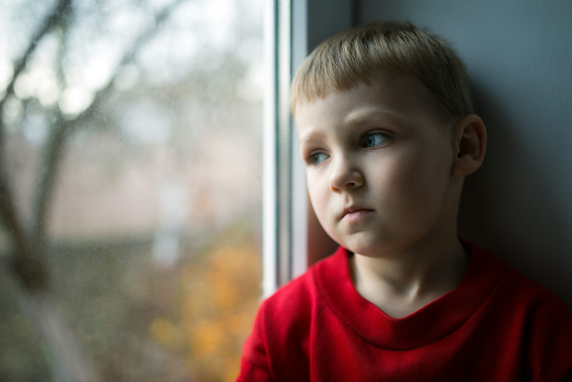 Young boy looking out of window
