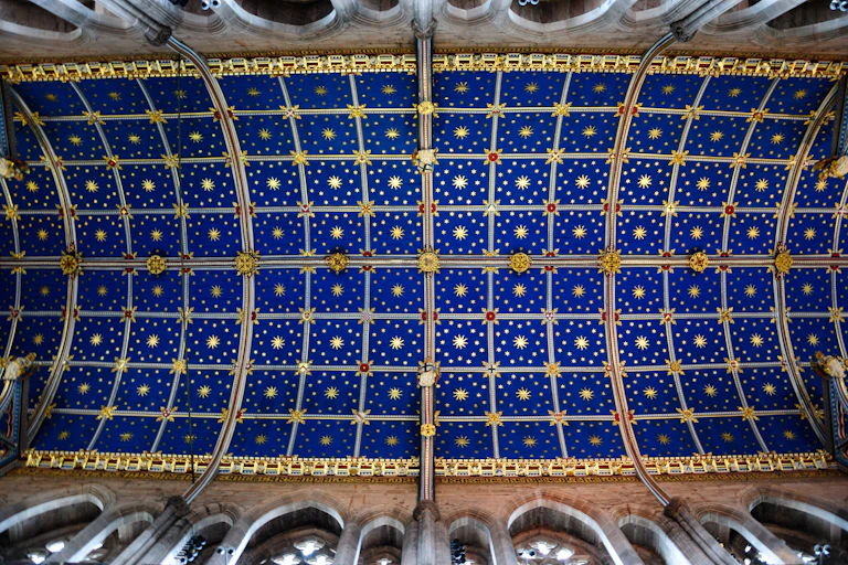 A blue and gilt church choir vaulted ceiling.