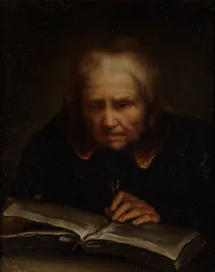 Retrato de un hombre mayor leyendo y palpando un libro.