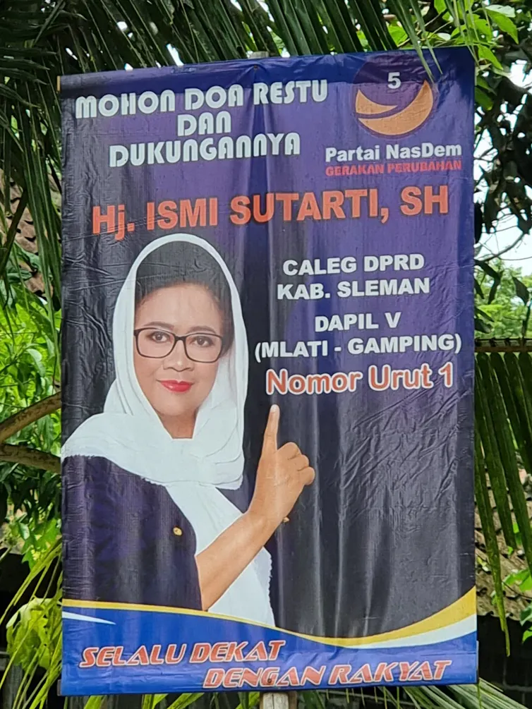 An Indonesian political poster featuring a woman smiling and holding up one finger