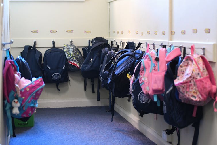Backpacks lined up outside a classroom.