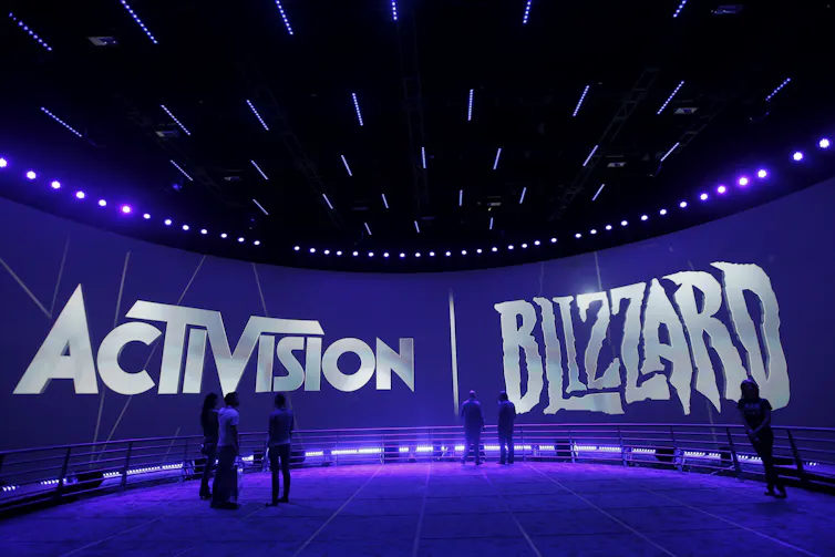 A large screen displaying the logos of Activision and Blizzard
