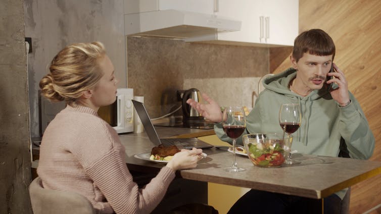 Woman frustrated by man answering phone call while they are having dinner