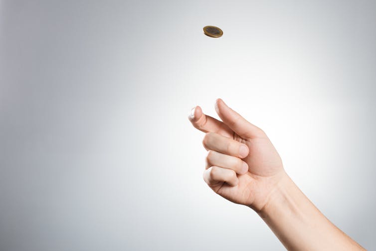 Hand tossing a coin