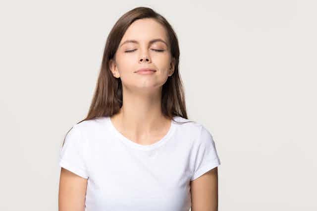 Girl with a serene expression breathing in scent