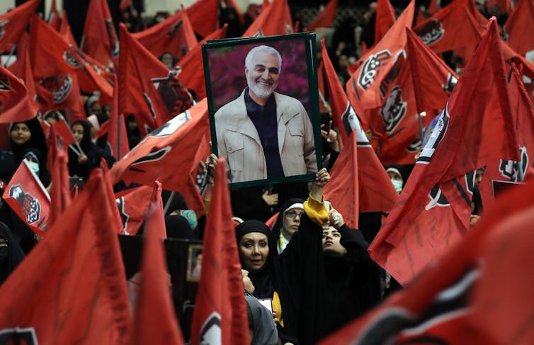 IKranians wave flags and hold up portraits of Quds force commander Qasem Soleimani, January 2024.