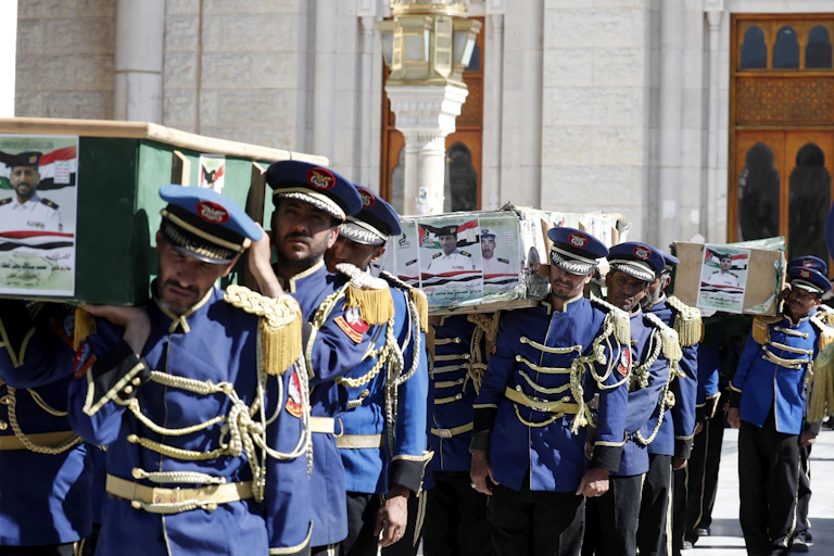 An honour guard of Houthi rebels carries the coffincs of victims from the US and UK airstrikes in Yemen, February 2024.