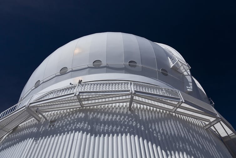 a large white dome looms against a dark sky