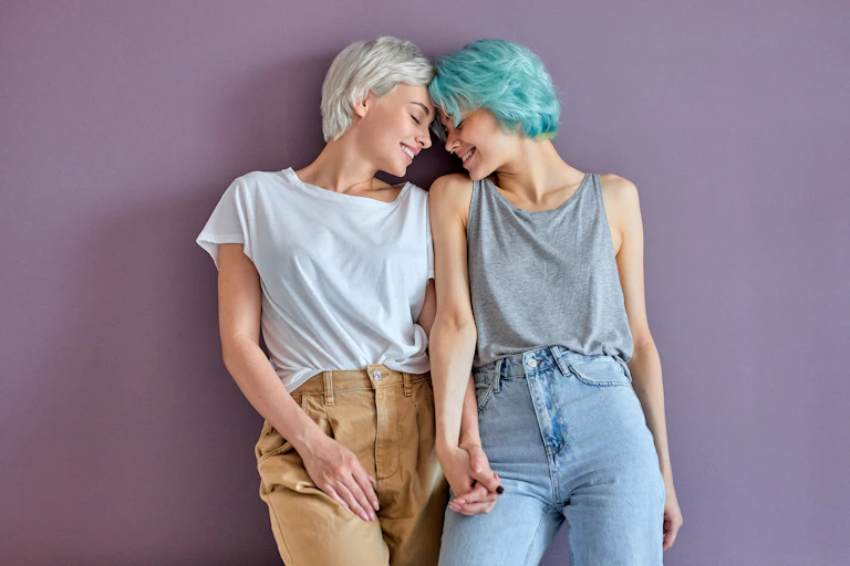 Dos mujeres enamoradas se miran y se cogen de las manos.
