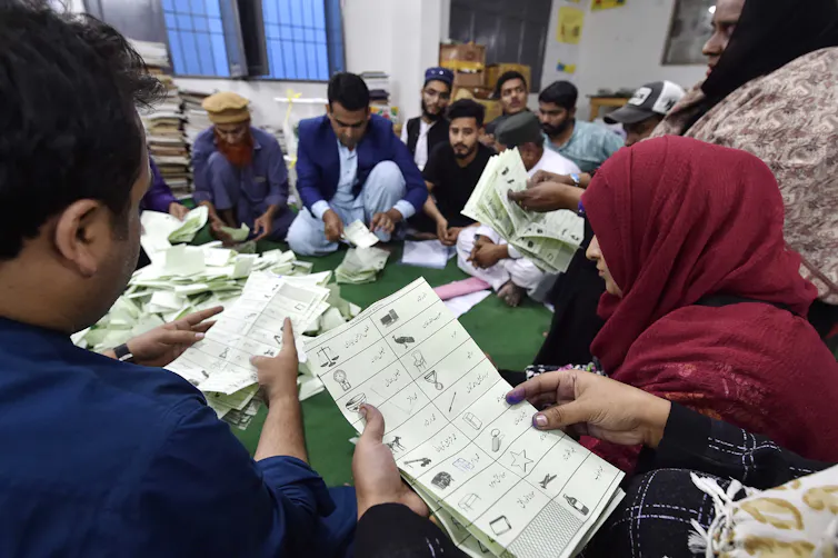 Polling officers sat on the floor counting ballots at a polling station.