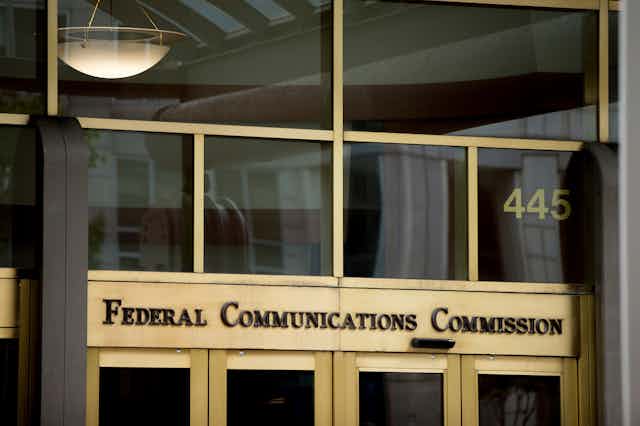 brass and glass entryway of an office building with lettering over the doors
