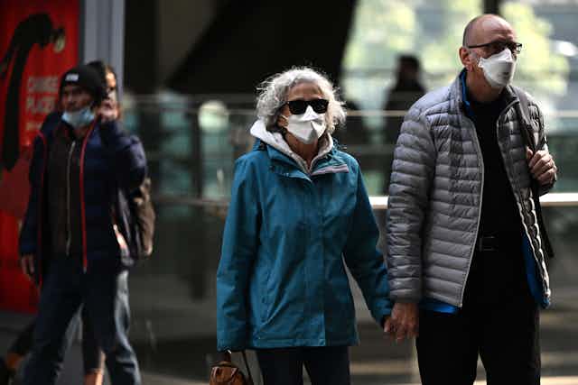 Two people wearing N95 masks.