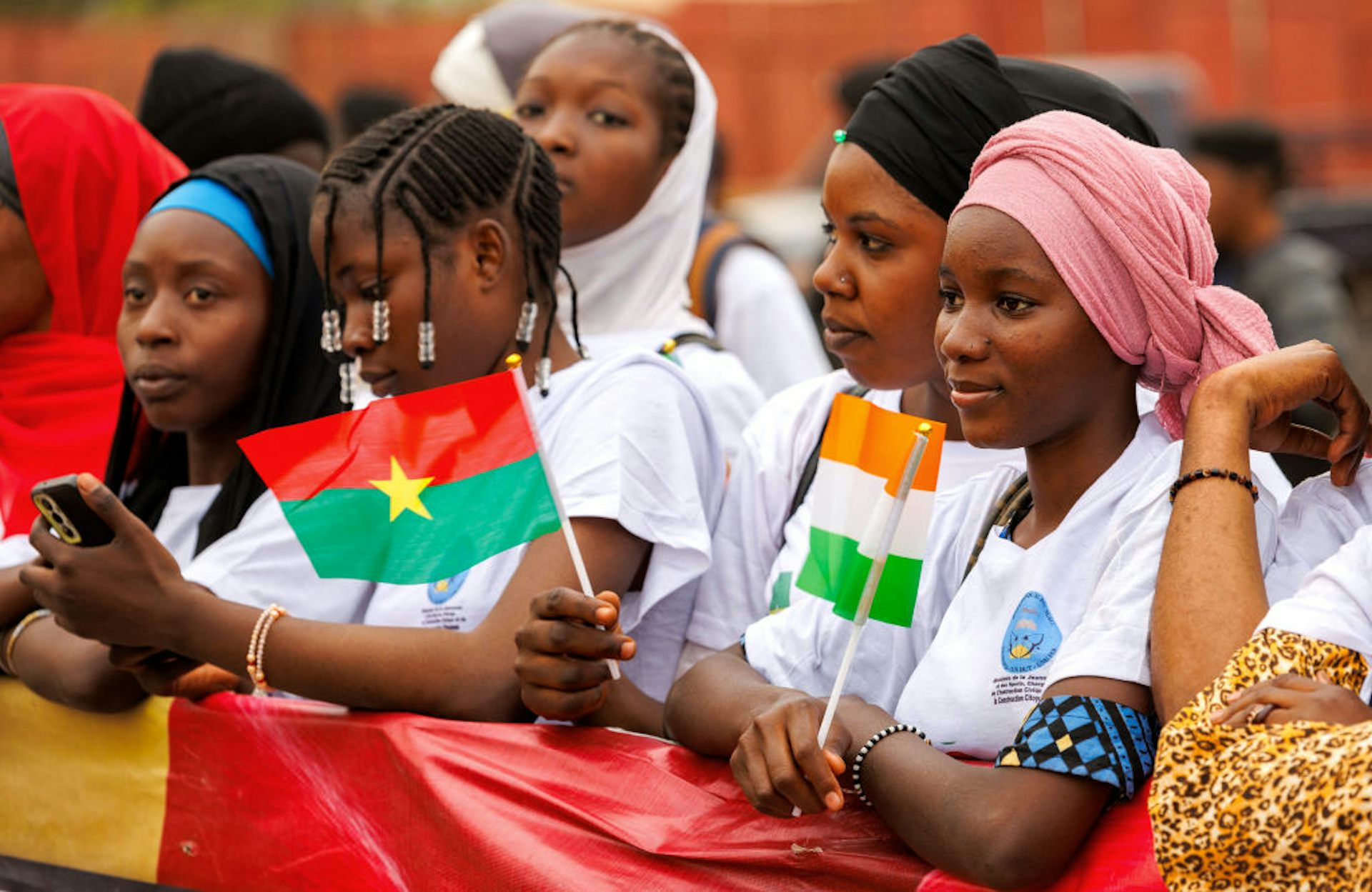 A groupof women holding a banner and small flags at a rally