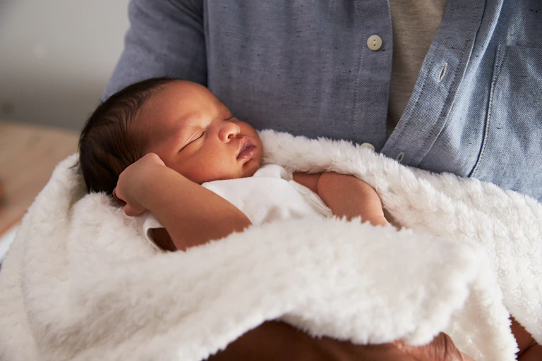 Baby held in a white blanket