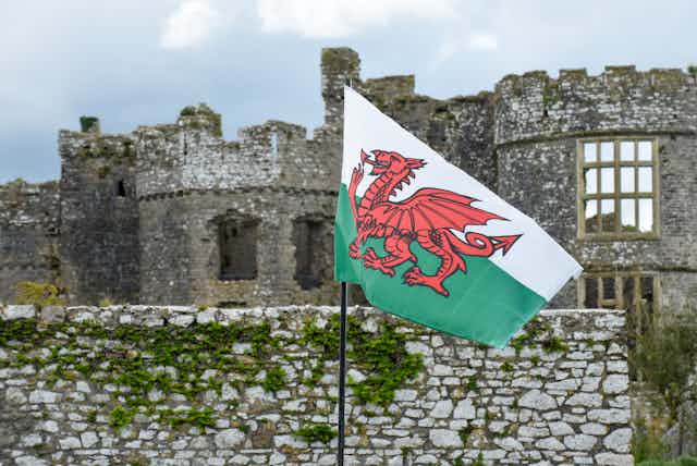 The Welsh flag in front of a ruined castle