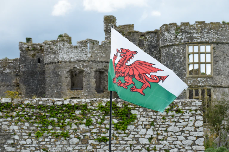 The Welsh flag in front of a ruined castle