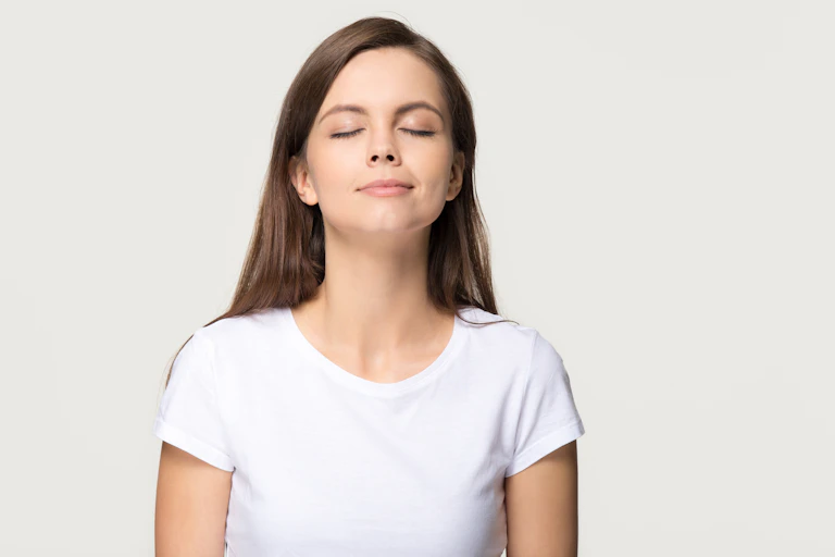 Uma mulher com expressão serena cheira o ar