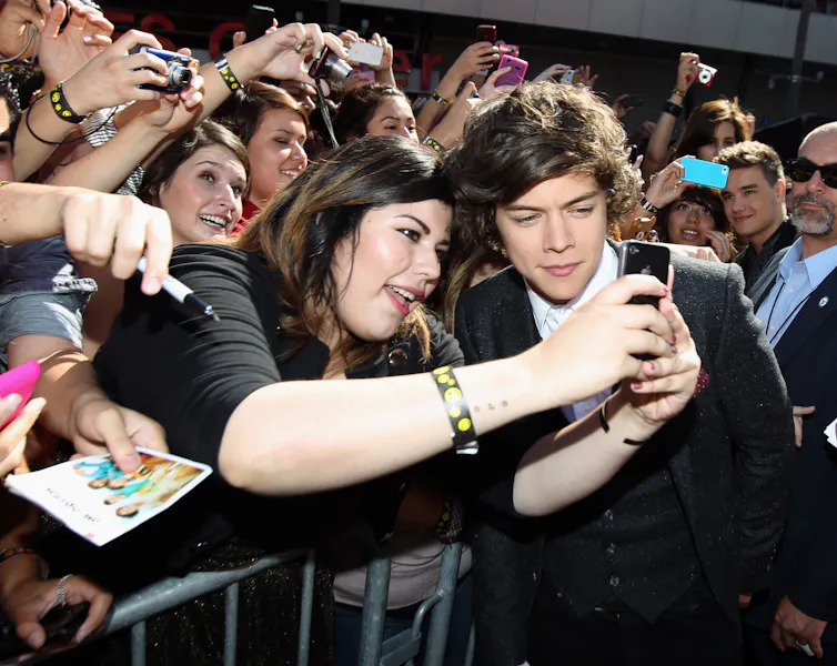 Harry Styles takes a selfie with a fan.