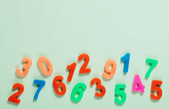 Magnet numerals, scattered on a plain background. 
