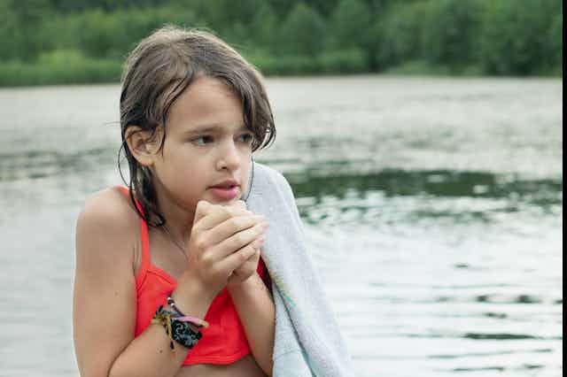 A girl shivering in the water.