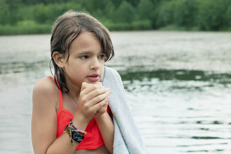 A girl shivering in the water.