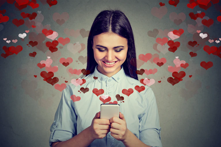 Woman with dark hair sending messages on a smartphone with red hearts flying out of it