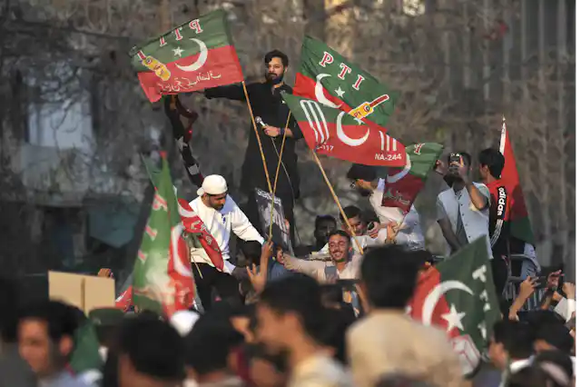 Political protestors raised up above a crowd waving flags.