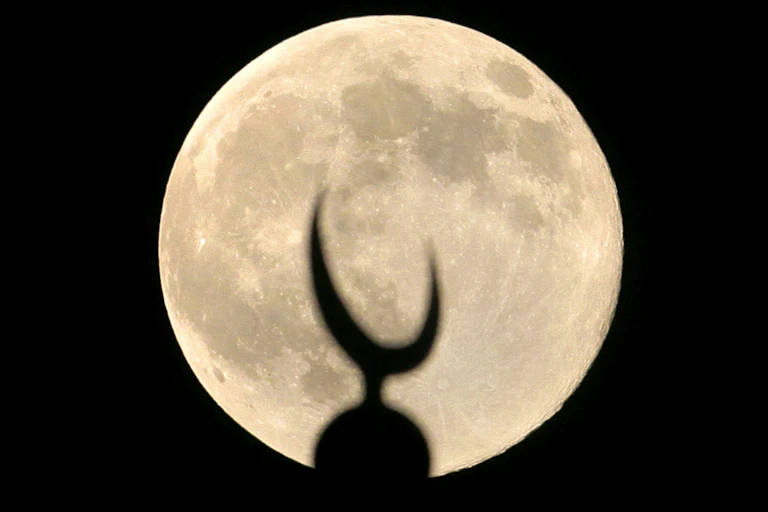 A bright moon illuminates a crescent dome.