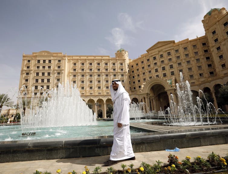 Arab walking past fountains at a big hotel in Riyadh