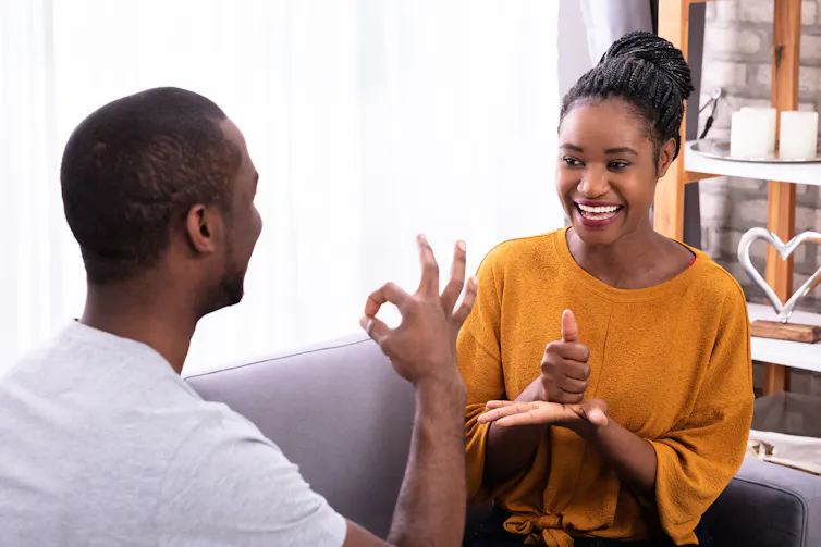A man and woman communicate using sign language.